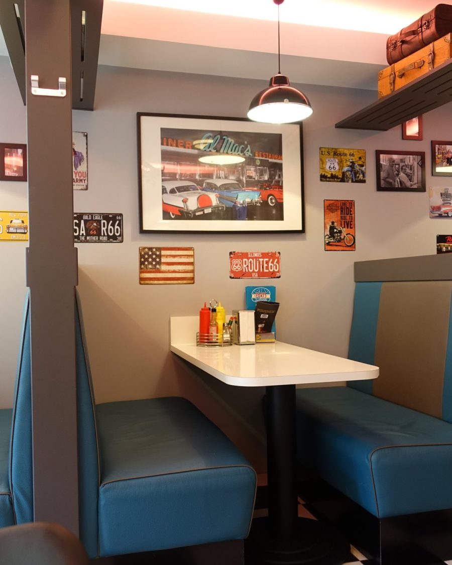 Warmly lit late-night diner interior, an anime-production key-art reference