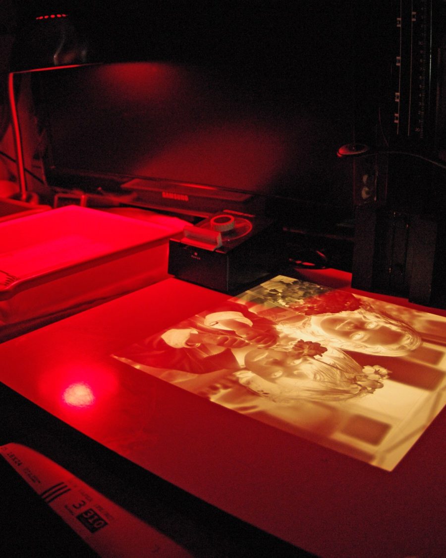 A photographer's darkroom with hanging prints, an anime-production key-art reference